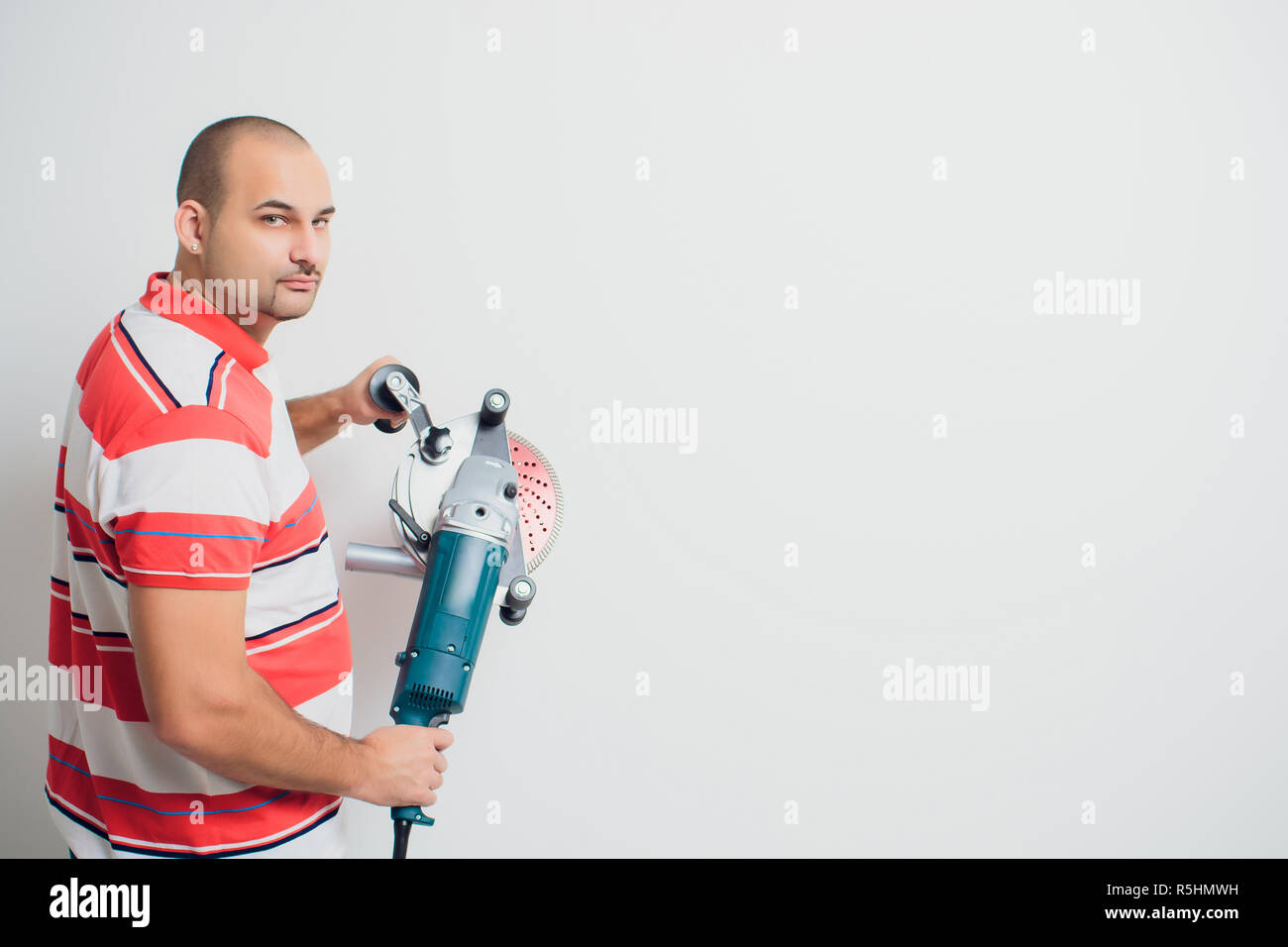 Construction worker with a puncher scream on a white background Stock Photo