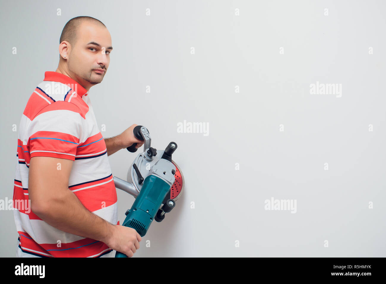 Construction worker with a puncher scream on a white background Stock Photo