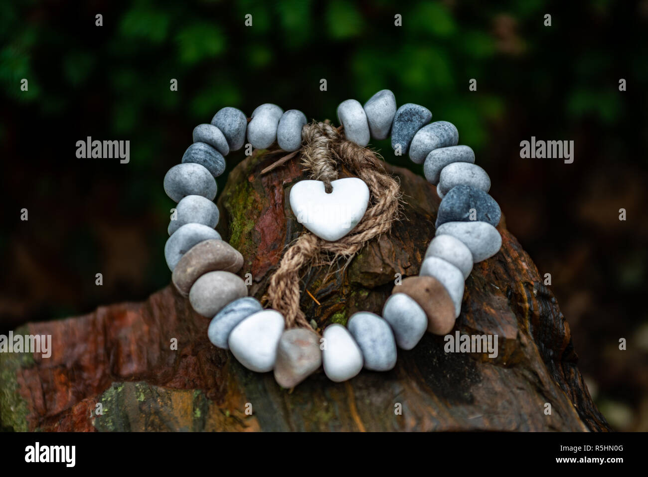 Chain of pebbles with stone heart as grave decoration- eternal love memorial Stock Photo