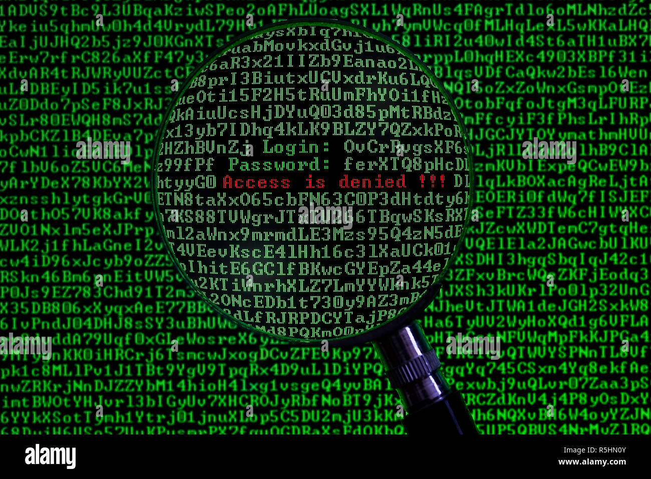 Concept of computer hacking in the form of a personal computer screen viewed through a magnifying glass Stock Photo