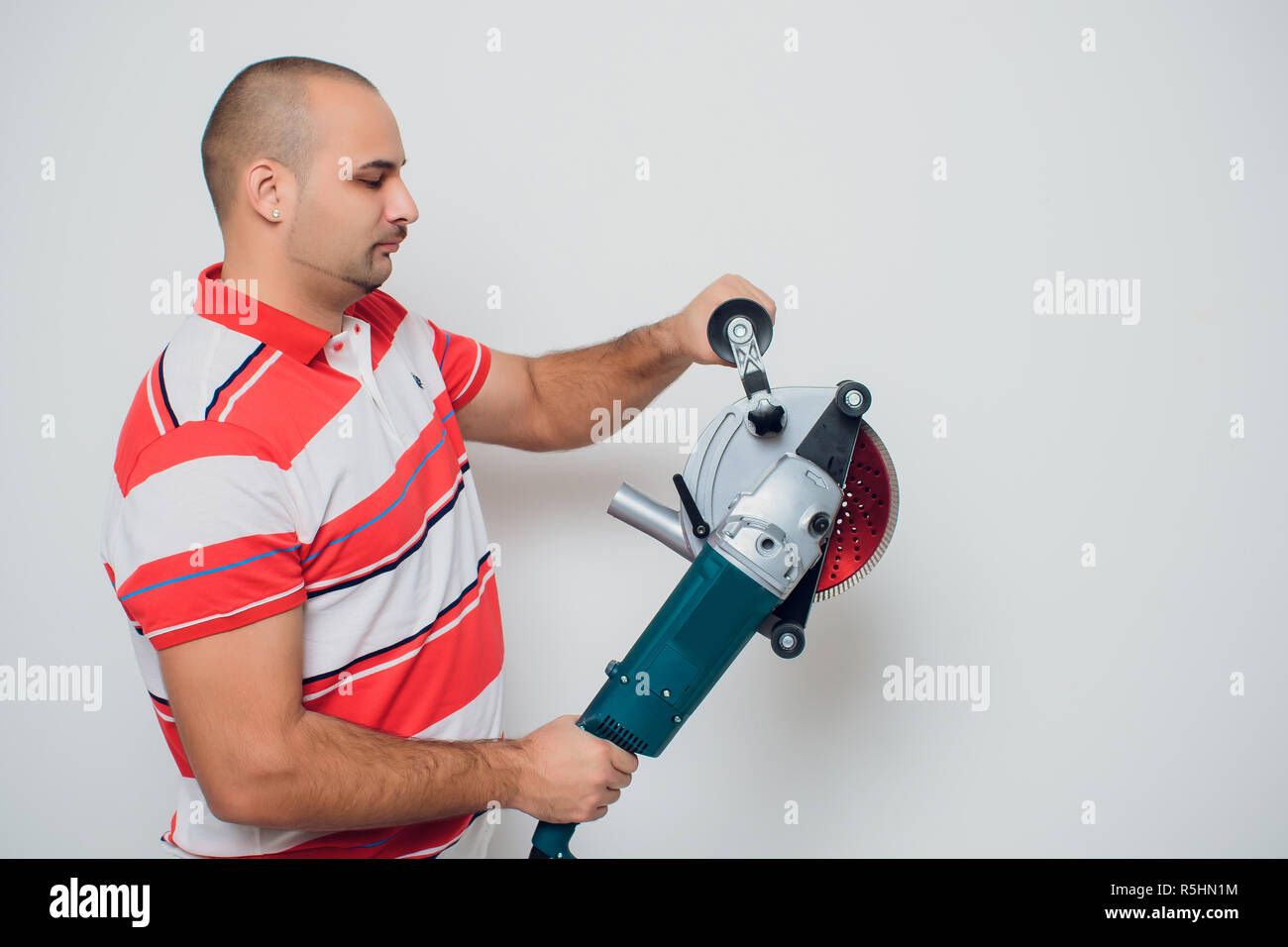 Construction worker with a puncher scream on a white background Stock Photo