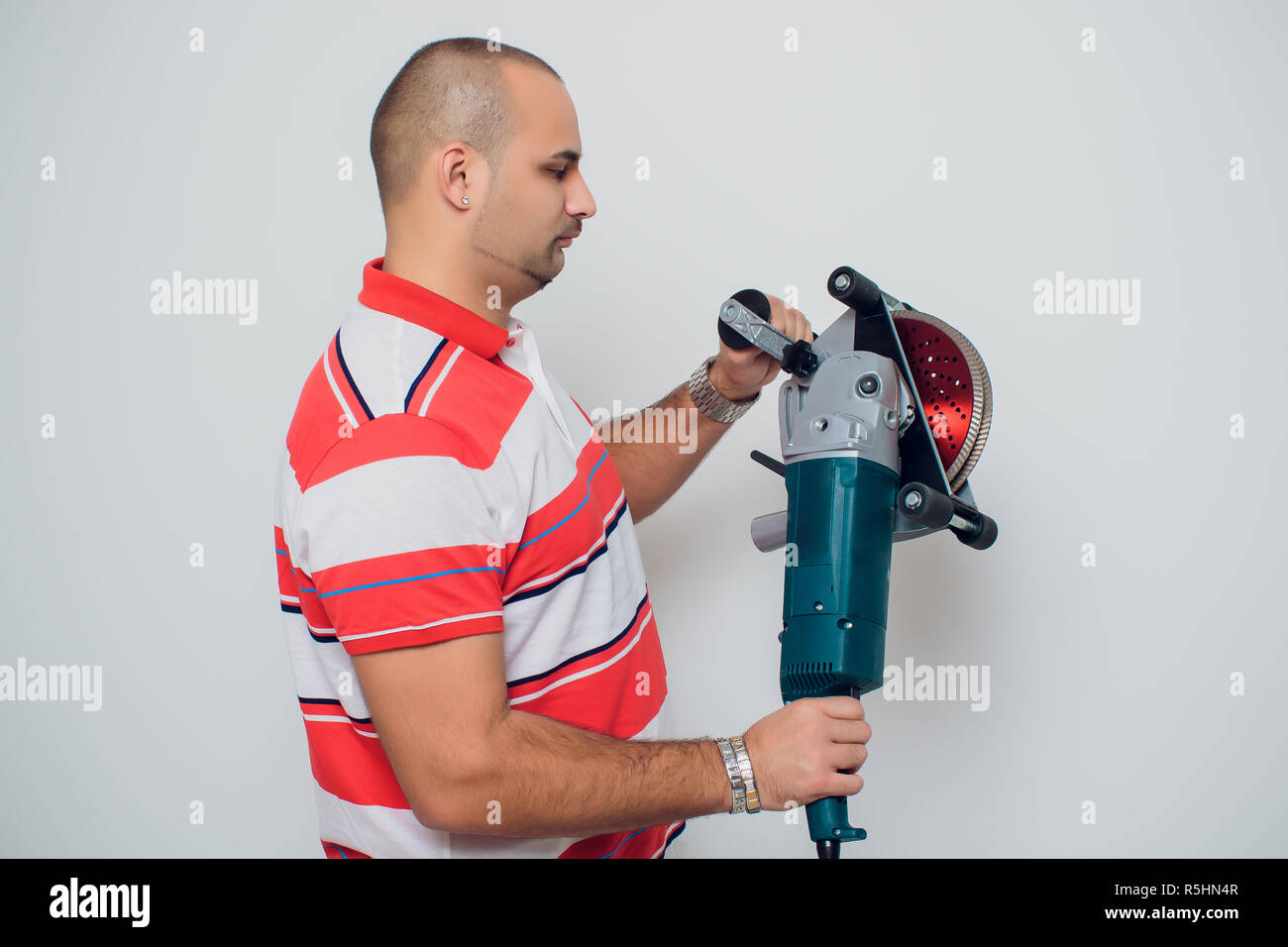 Construction worker with a puncher scream on a white background Stock Photo