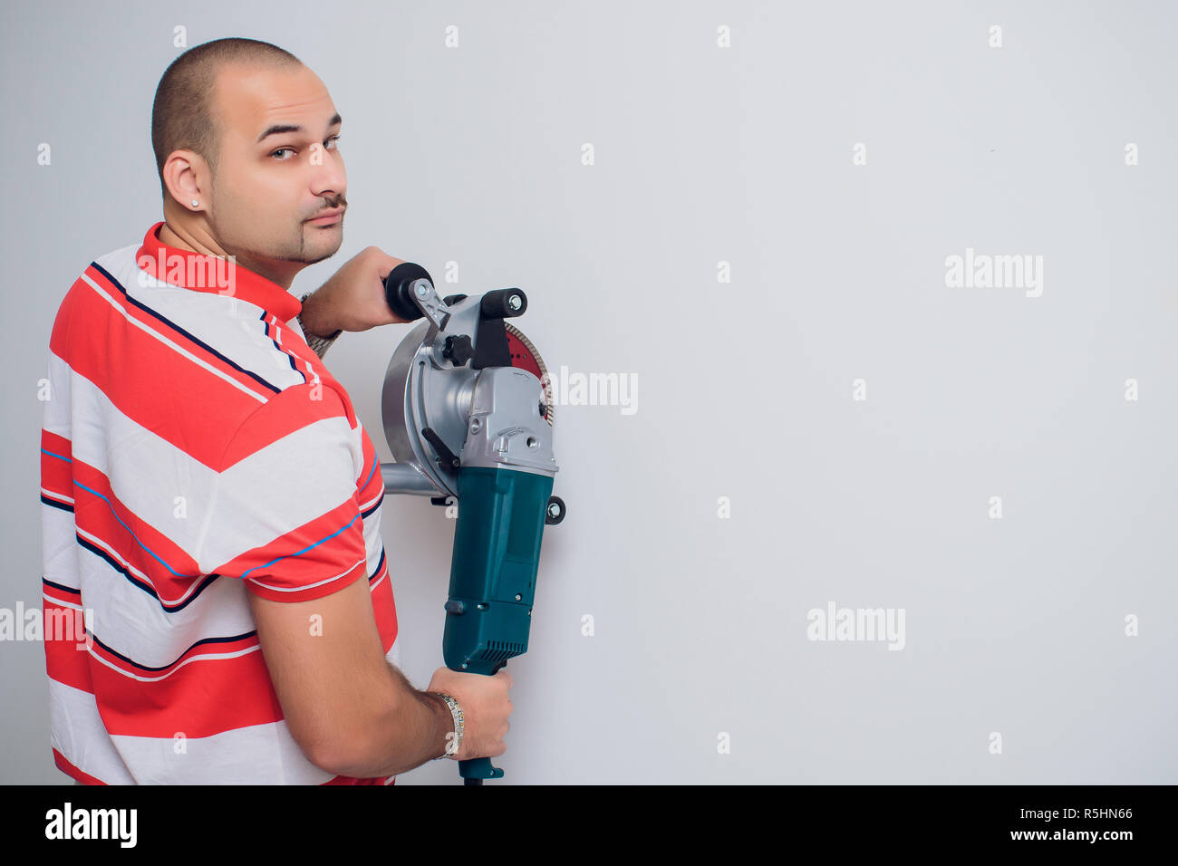 Construction worker with a puncher scream on a white background Stock Photo