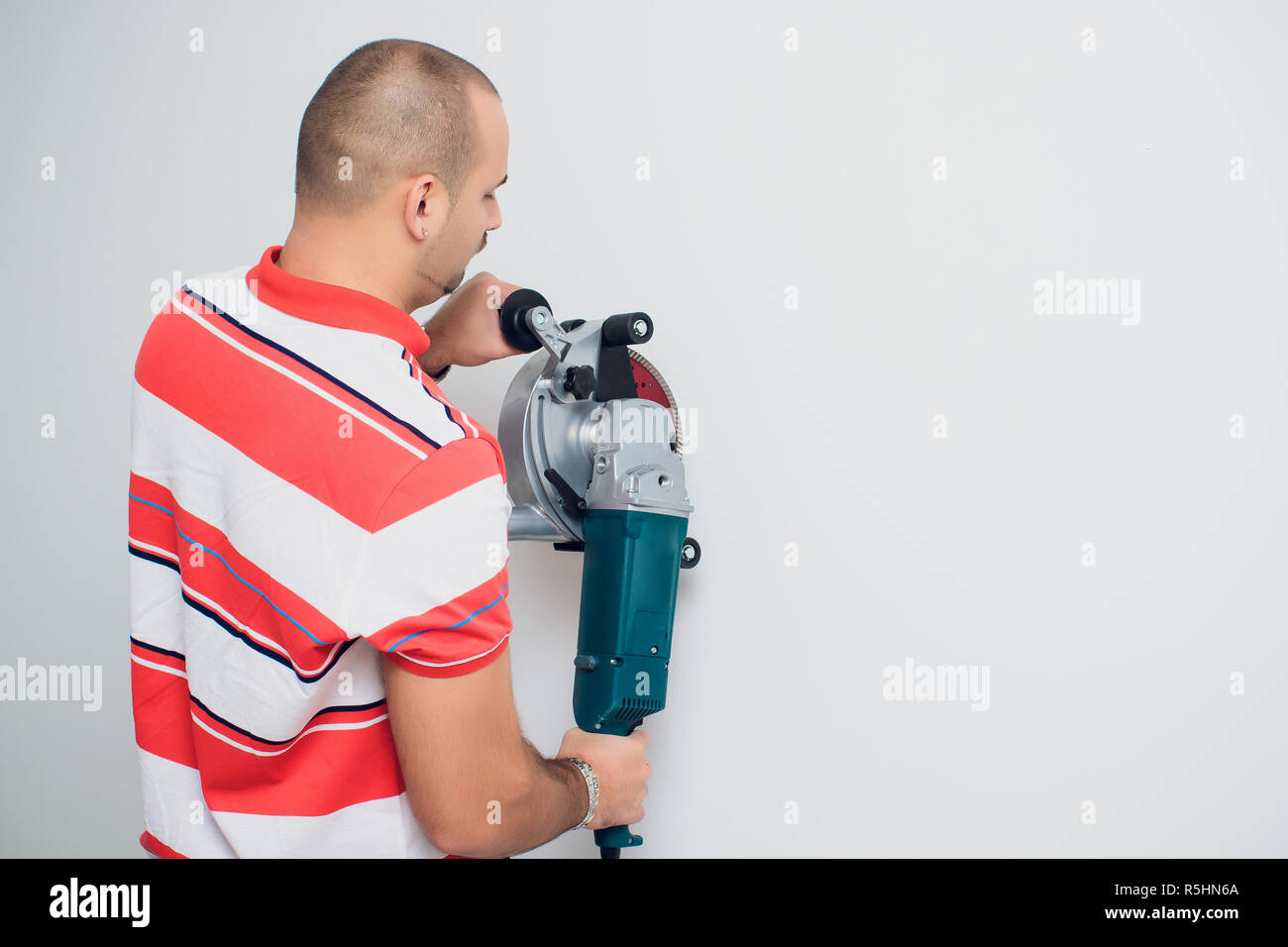 Construction worker with a puncher scream on a white background Stock Photo