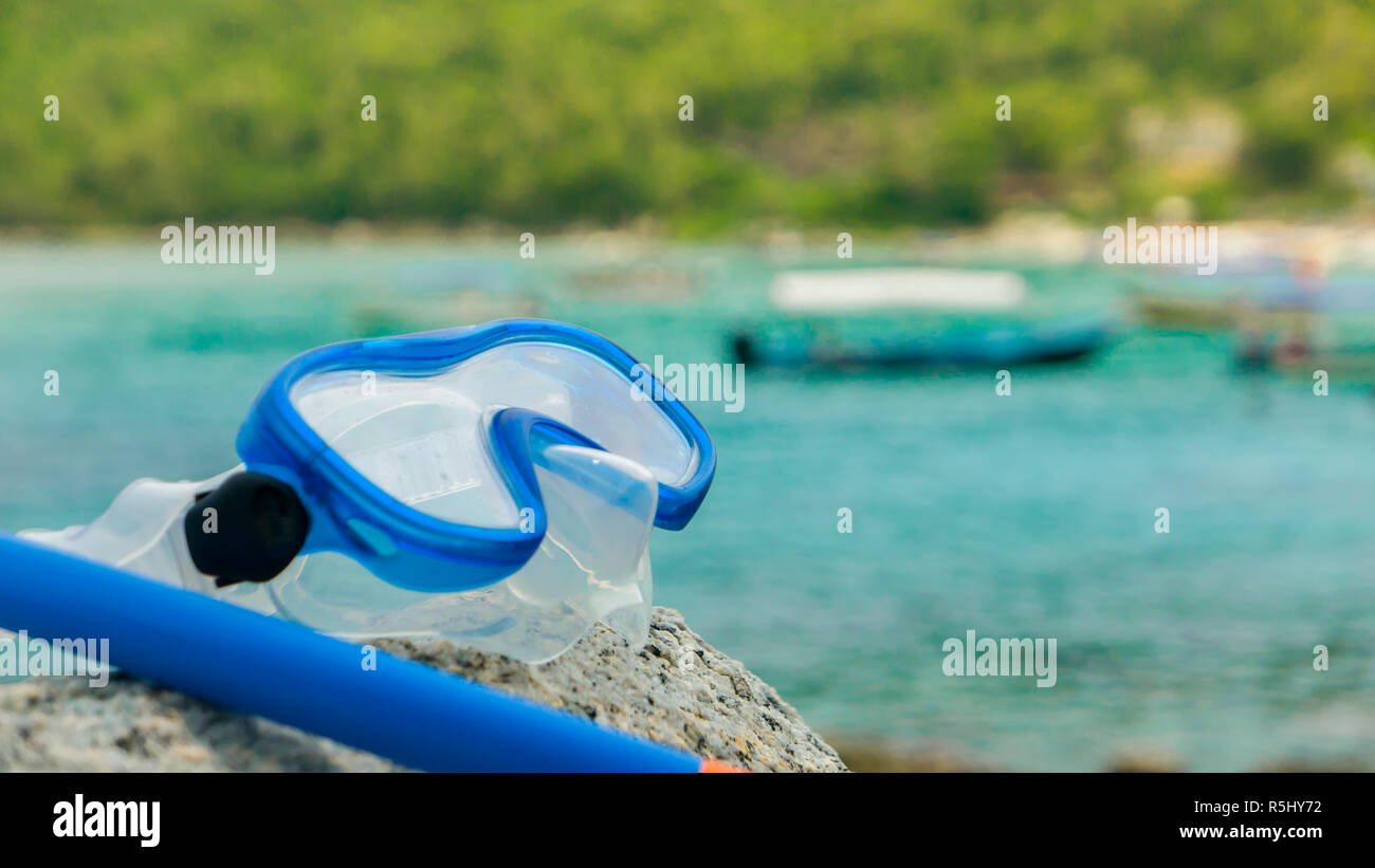 Snorkeling equipment snorkel and diving google on the stone. Tropical
