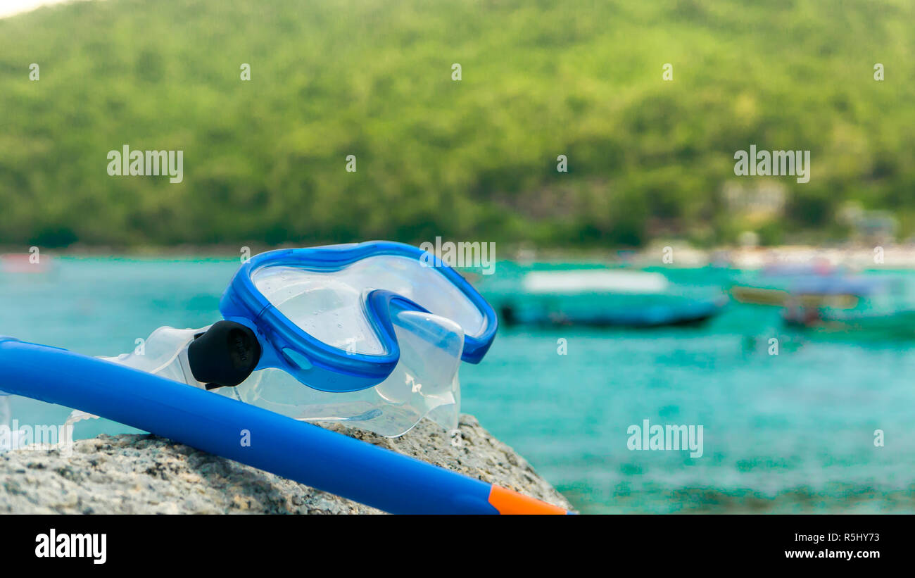 Snorkeling equipment snorkel and diving google on the stone. Tropical