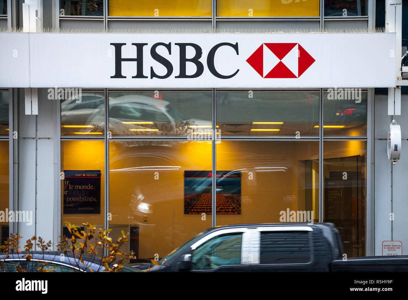 MONTREAL, CANADA - NOVEMBER 5, 2018: Logo of the HSBC Bank, on their main branch in Montreal with cars passing by. HSBC is a british bank spread world Stock Photo