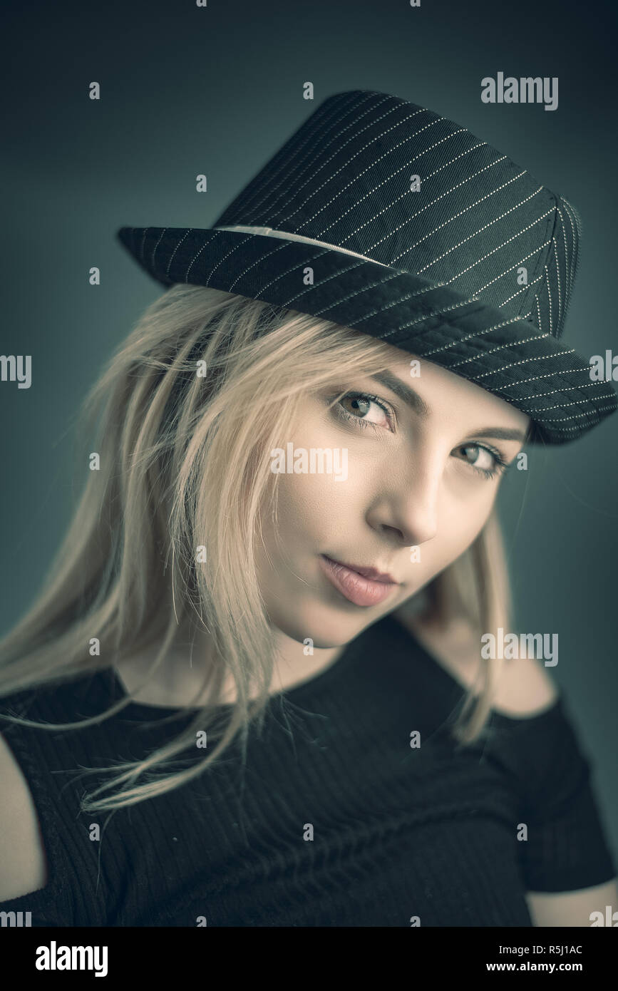 Studio Portrait of a young blonde woman wearing a black hat Stock Photo