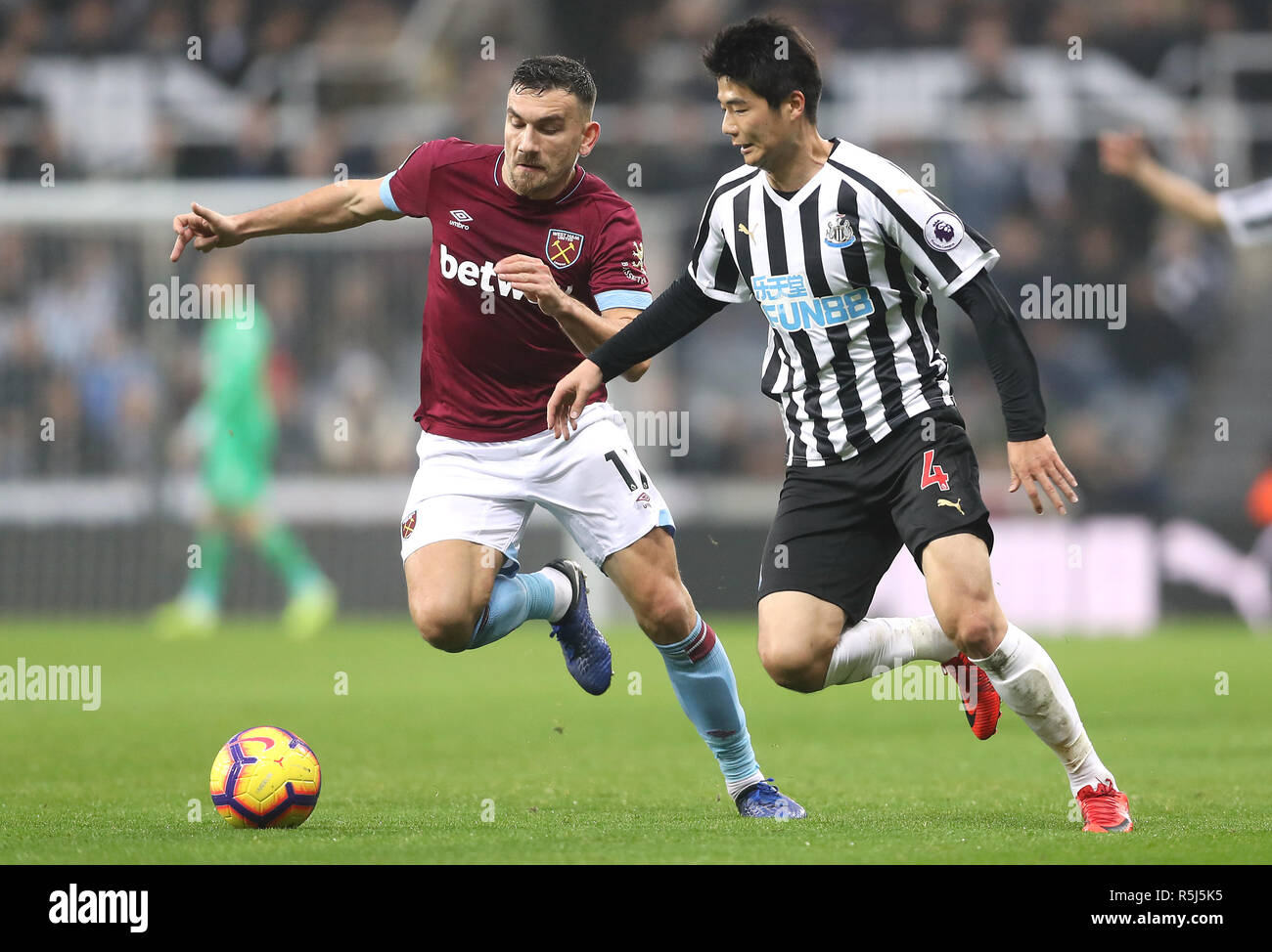 West Ham United's Robert Snodgrass (left) and Newcastle United's Ki Sung-yueng battle for the ball during the Premier League match at St James' Park, Newcastle. Stock Photo
