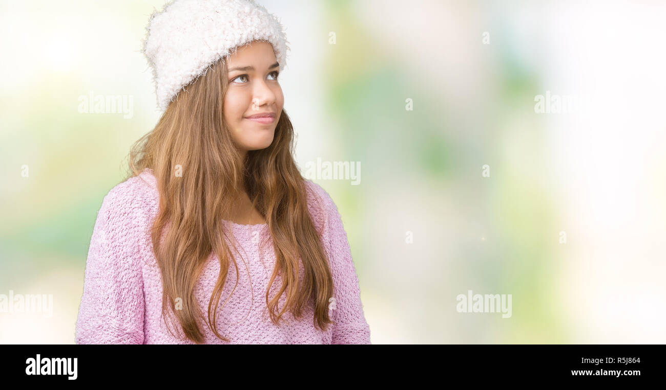 Young Beautiful Brunette Woman Wearing Sweater And Winter Hat Over