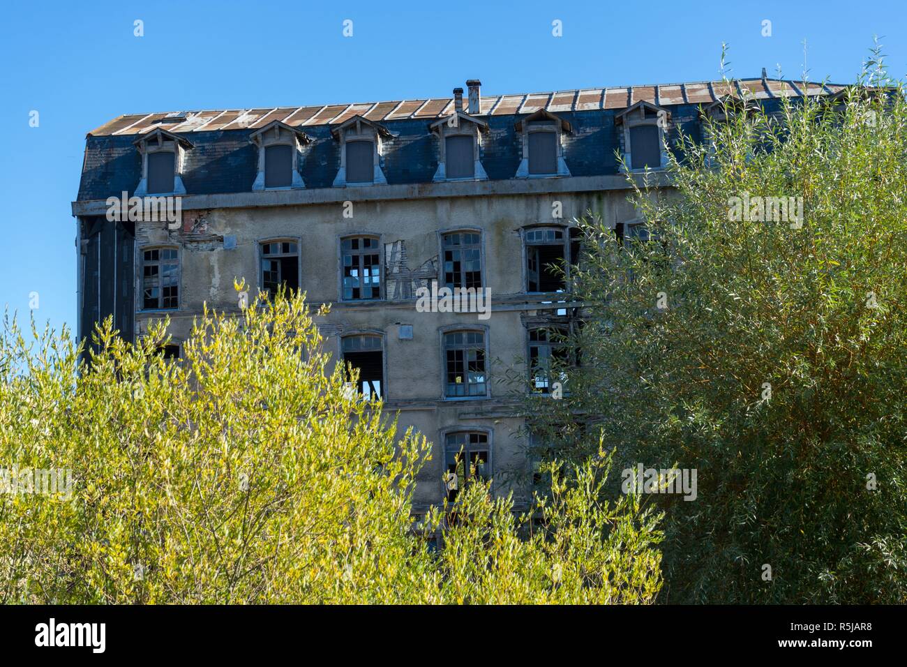 Trees in front of old mill building in Bar sur Seine in Aube France Stock Photo