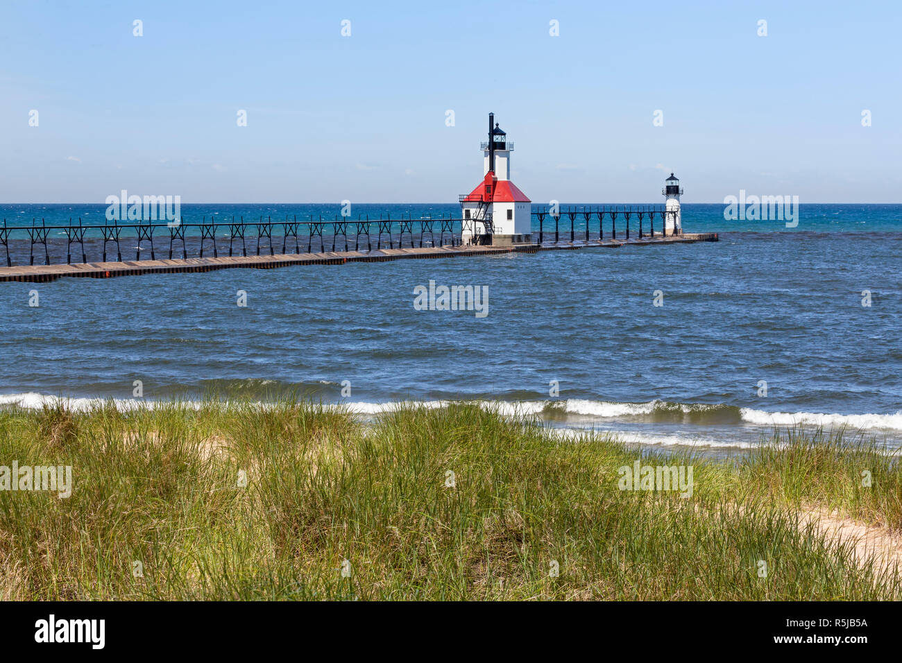Photographed atop a dune, two lighthouses mark the mouth of the