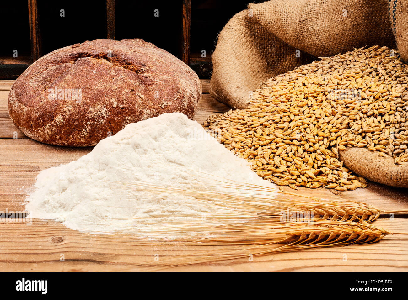 Bread with corn and wheat flour on wooden table Stock Photo