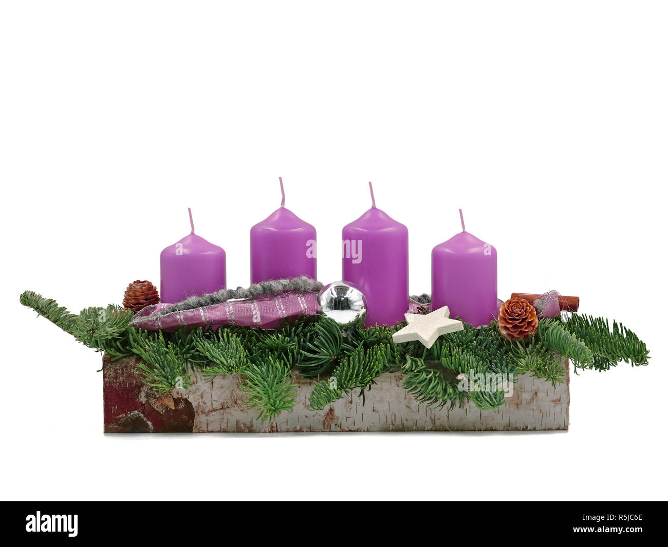 four violet advent candles with twigs isolated on white background Stock Photo