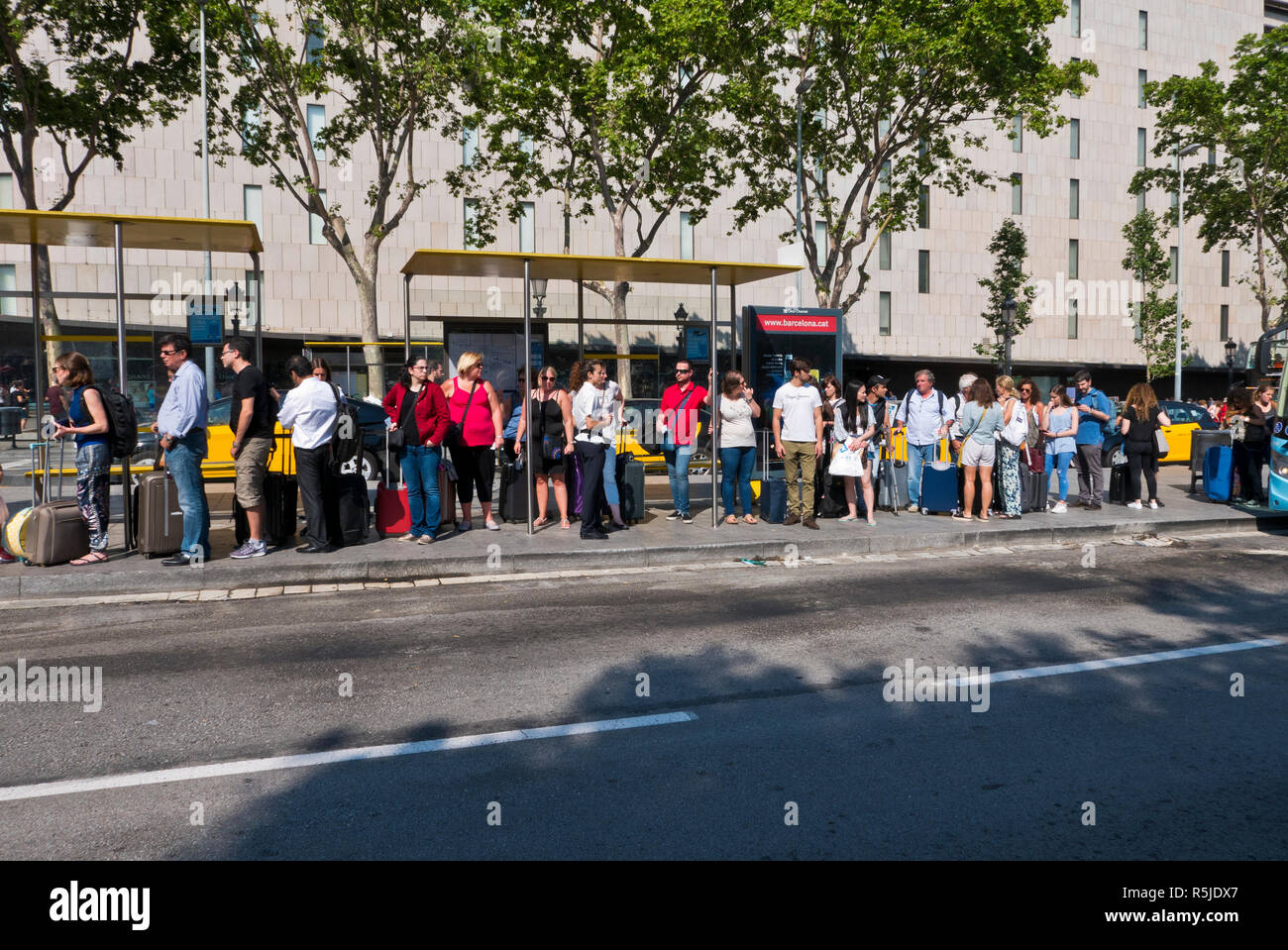 People queuing at a bus stop In Placa De Catalunya, Barcelona, Spain Stock Photo