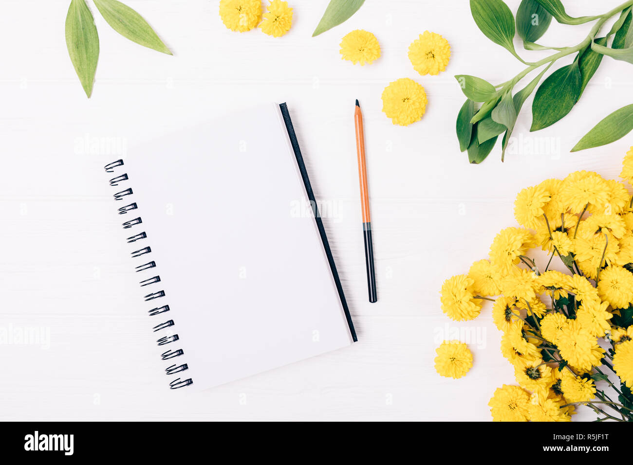 Spring flat lay composition open blank notepad and pencil next to ...
