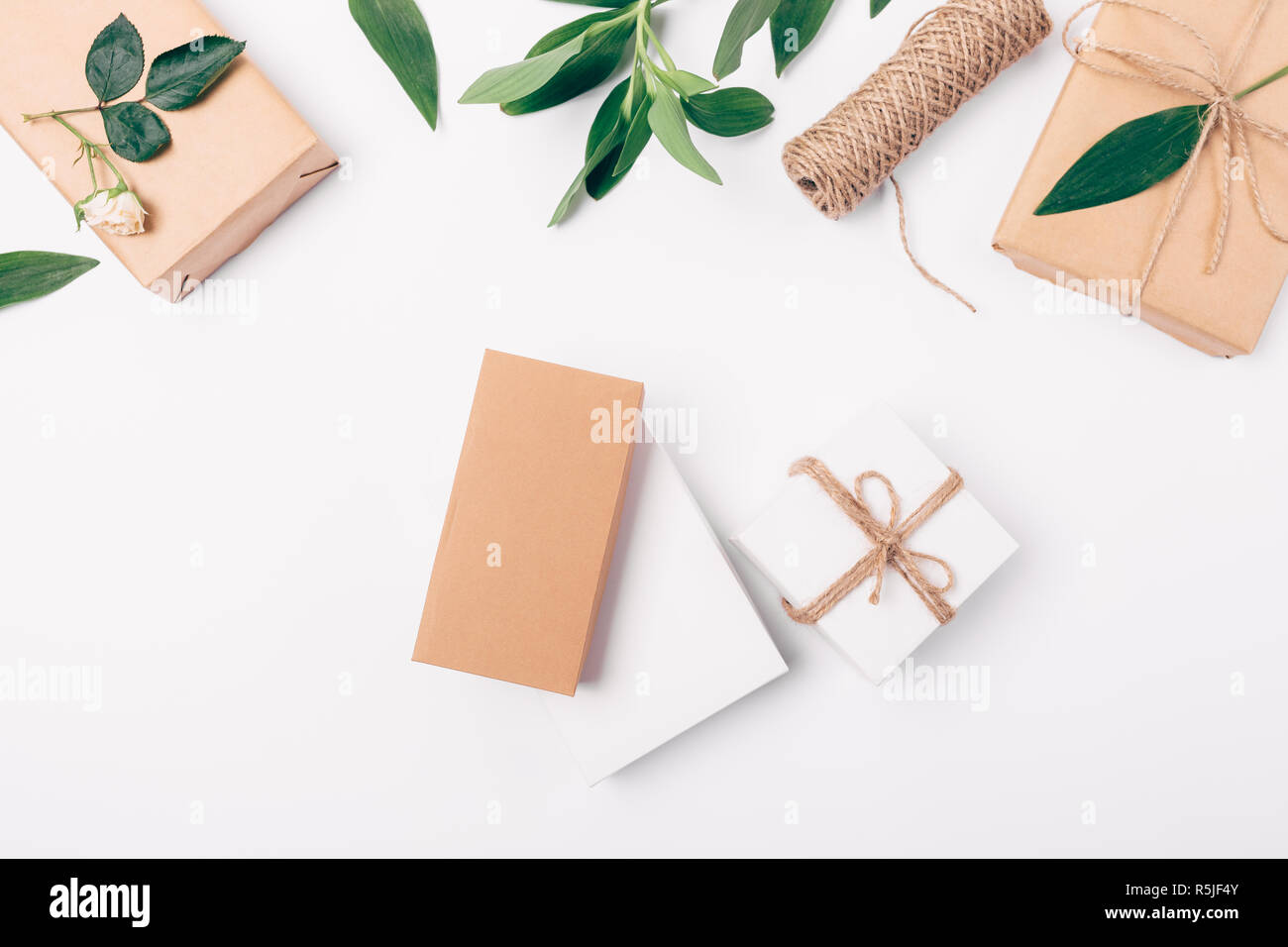 Flat lay floral arrangement of gift boxes on white background, top view ...