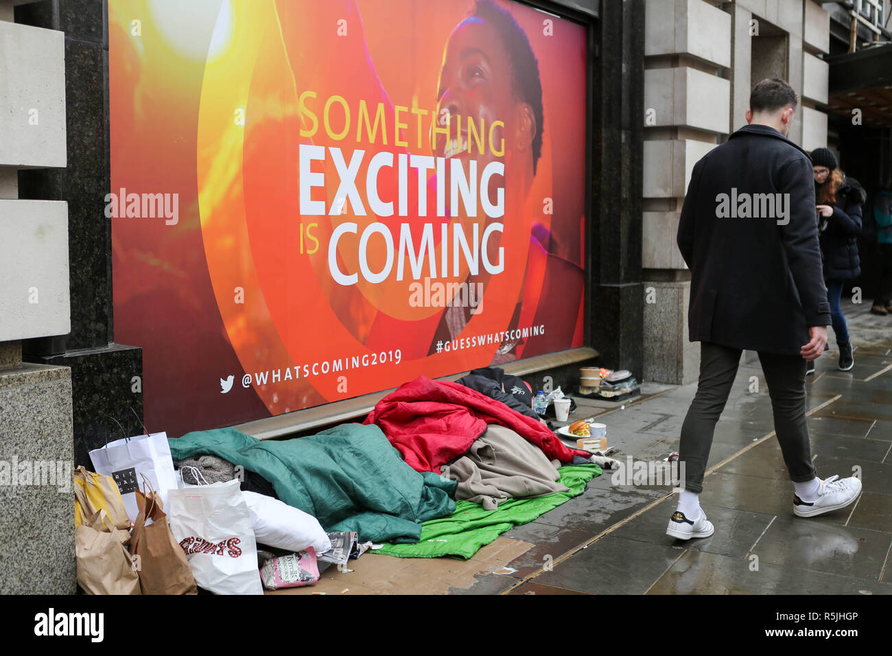 Regents Street, London, UK1st Dec, 2018. A homeless person and belongings asleep, as people walk by and do their Christmas shopping. Penelope Barritt/Alamy Live News Stock Photo