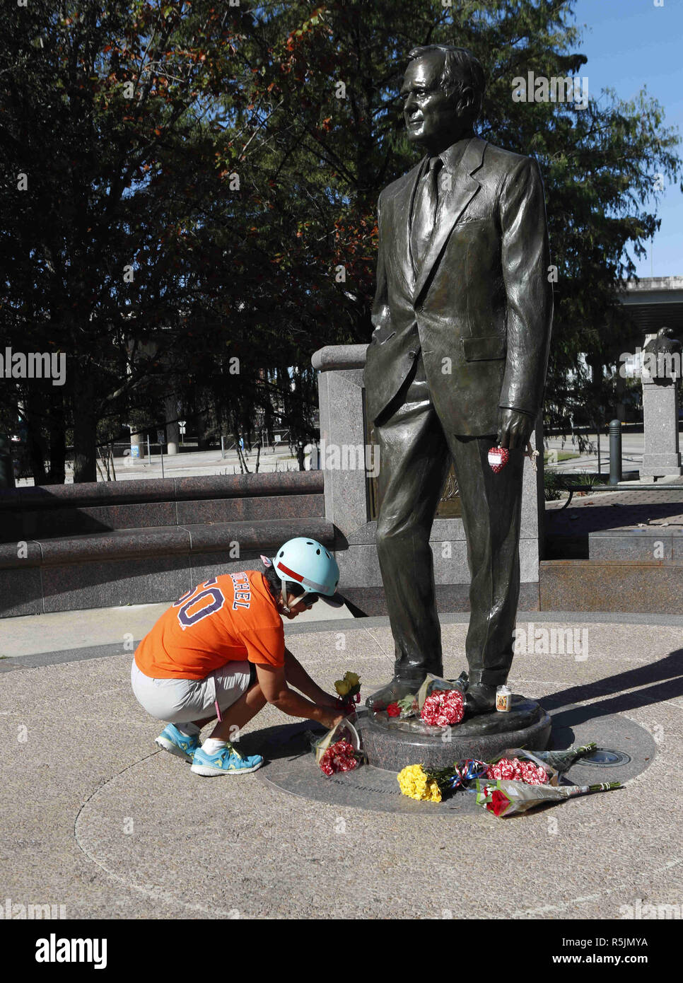 Houston, USA. 1st Dec, 2018. A citizen lays flowers in front of a statue of former U.S. President George H.W. Bush in Houston, Texas, the United States, on Dec. 1, 2018. George H.W. Bush, the 41st president of the United States, has died Friday at the age of 94, according to a statement from his office. Credit: Steven Song/Xinhua/Alamy Live News Stock Photo