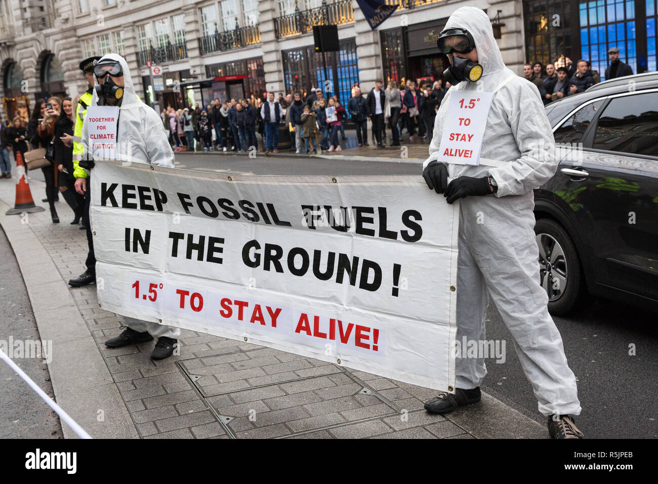 London, UK. 1st December, 2018. Environmental campaigners hold a banner reading 'Keep fossil fuels in the ground' on the Together for Climate Justice demonstration in protest against Government policies in relation to climate change, including Heathrow expansion and fracking. Following a rally outside the Polish embassy, chosen to highlight the UN's Katowice Climate Change Conference which begins tomorrow, protesters marched to Downing Street. Credit: Mark Kerrison/Alamy Live News Stock Photo