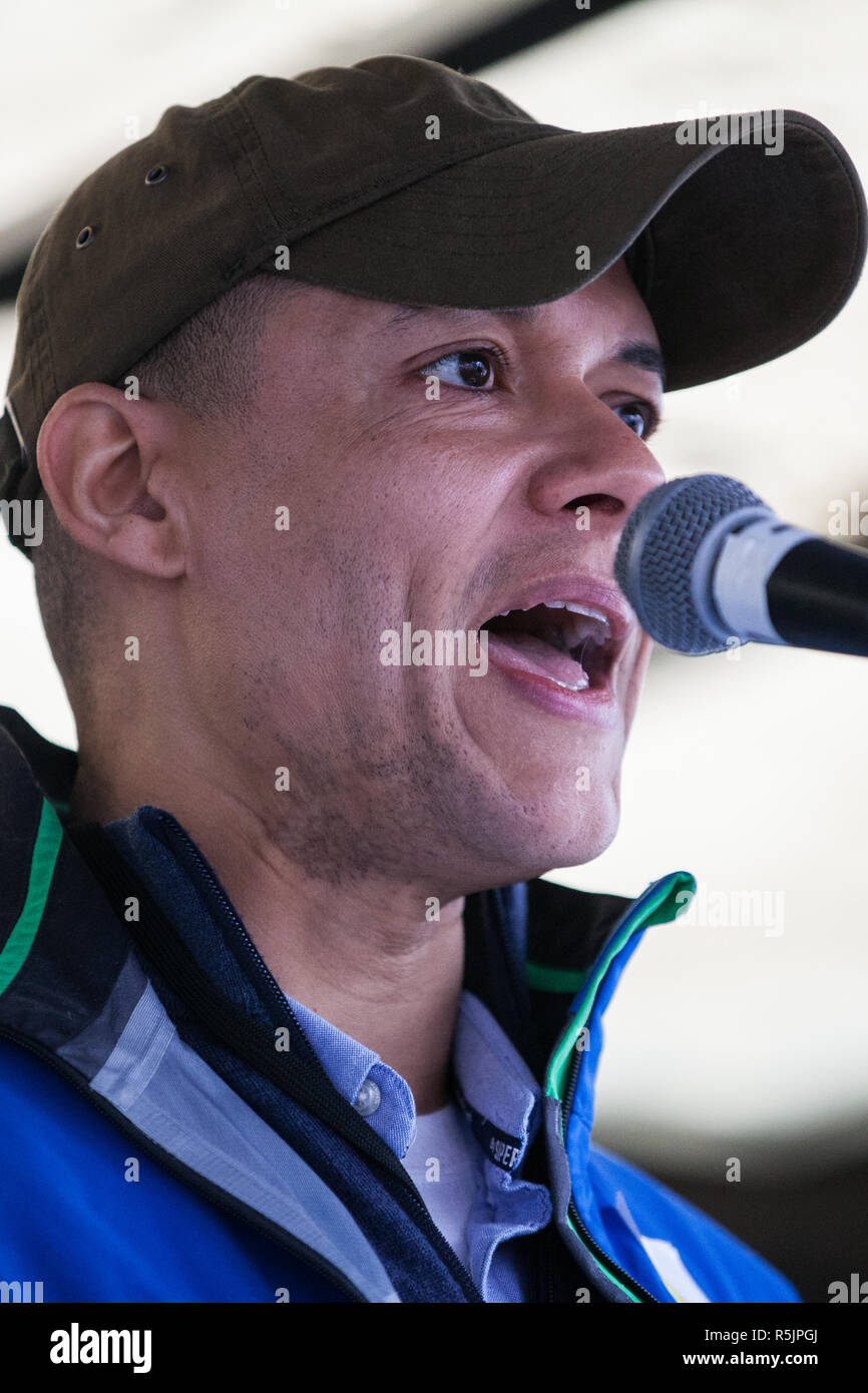 London, UK. 1st December, 2018. Clive Lewis MP, Shadow Treasury Minister for Sustainable Economics, addresses the Together for Climate Justice demonstration against Government policies in relation to climate change, including Heathrow expansion and fracking. Following a rally outside the Polish embassy, chosen to highlight the UN's Katowice Climate Change Conference which begins tomorrow, protesters marched to Downing Street. Credit: Mark Kerrison/Alamy Live News Stock Photo
