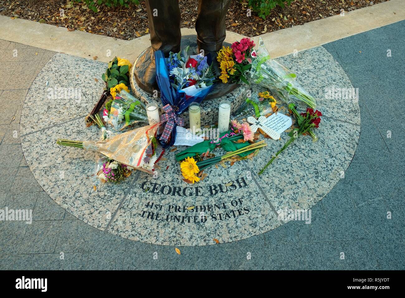 College Station, Texas, USA. 1 Dec., 2018. Flowers at the base of the George H.W. Bush statue outside the George Bush Presidential Library in College Station, Texas, USA.  Former President Bush died Nov. 30, 2018 at the age of 94. Stock Photo