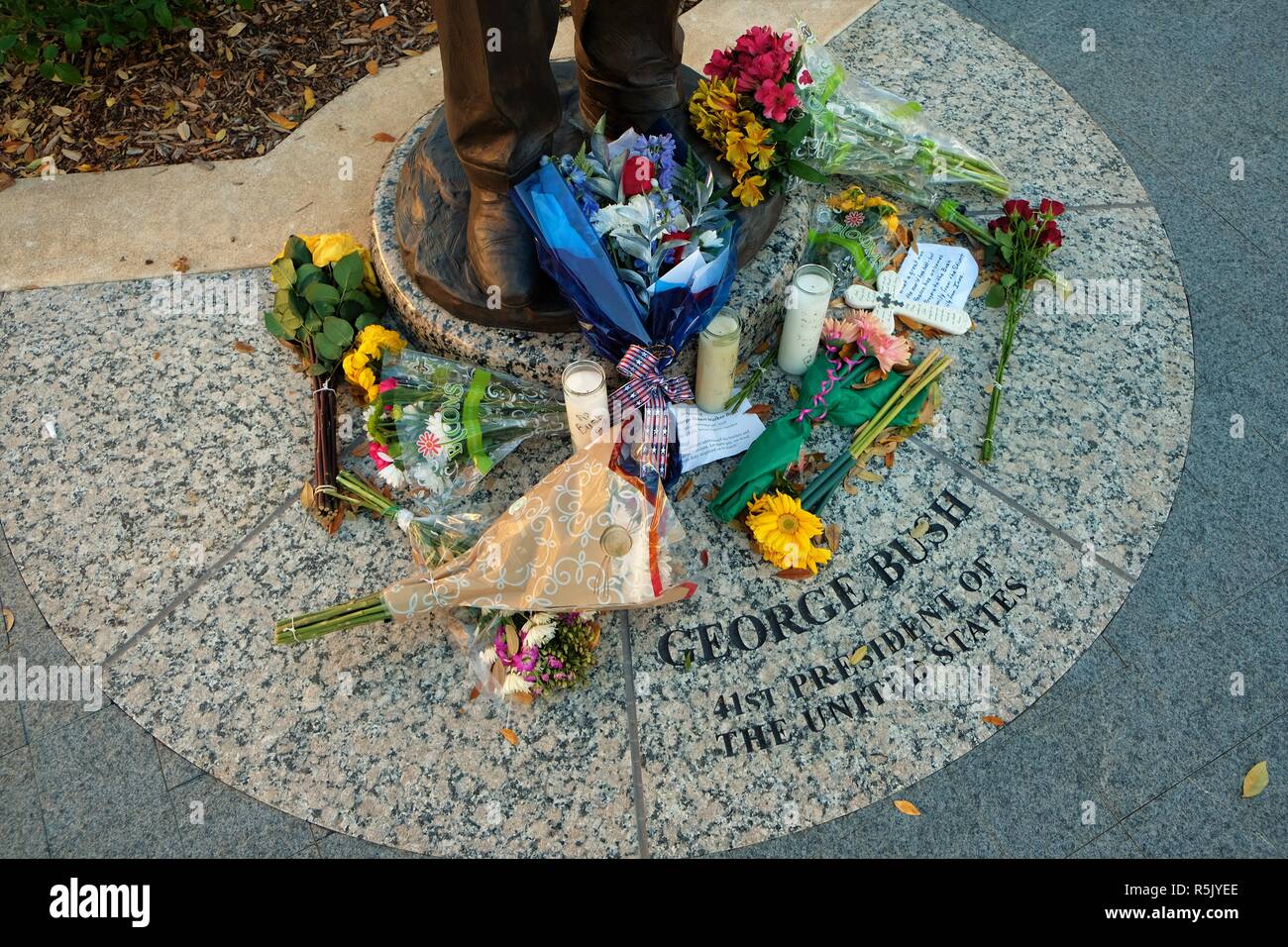 College Station, Texas, USA. 1 Dec., 2018. Flowers at the base of the George H.W. Bush statue outside the George Bush Presidential Library in College Station, Texas, USA.  Former President Bush died Nov. 30, 2018 at the age of 94. Stock Photo