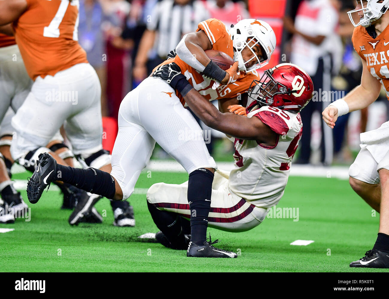 Texas Longhorns running back Keaontay Ingram (26) is stopped behind the  line by Oklahoma defensive lineman Kenneth Mann (55) during the Dr. Pepper  Big-12 Championship between the Oklahoma Sooners vs Texas Longhorns