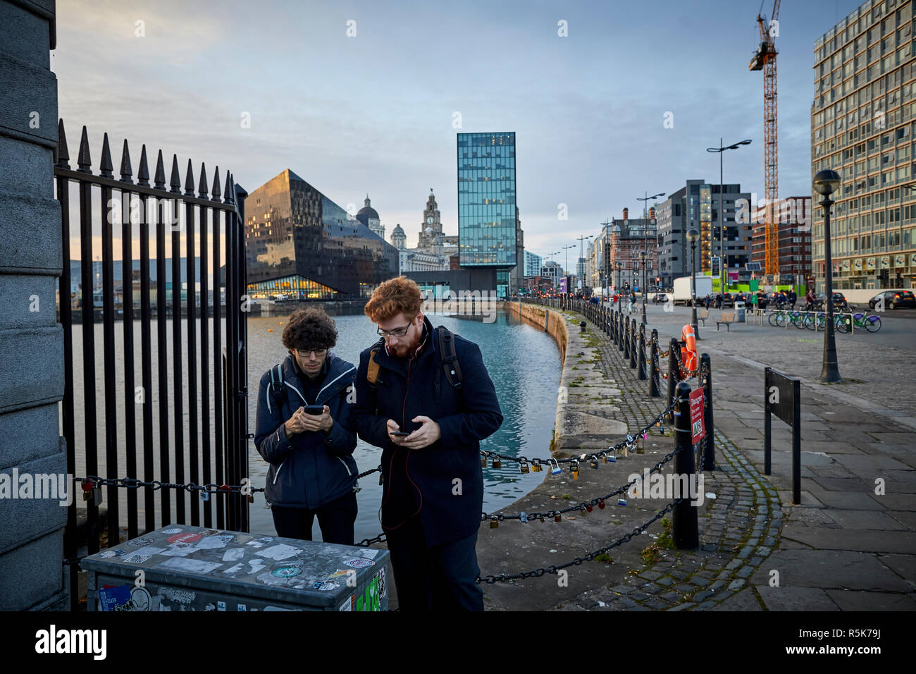 Liverpool Waterfront Albert Docks tourists using mobile phones Stock Photo