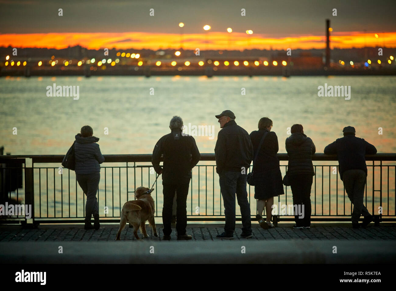 Liverpool Waterfront Pier Head looking across the river mersey into Birkenhead at sunset Stock Photo