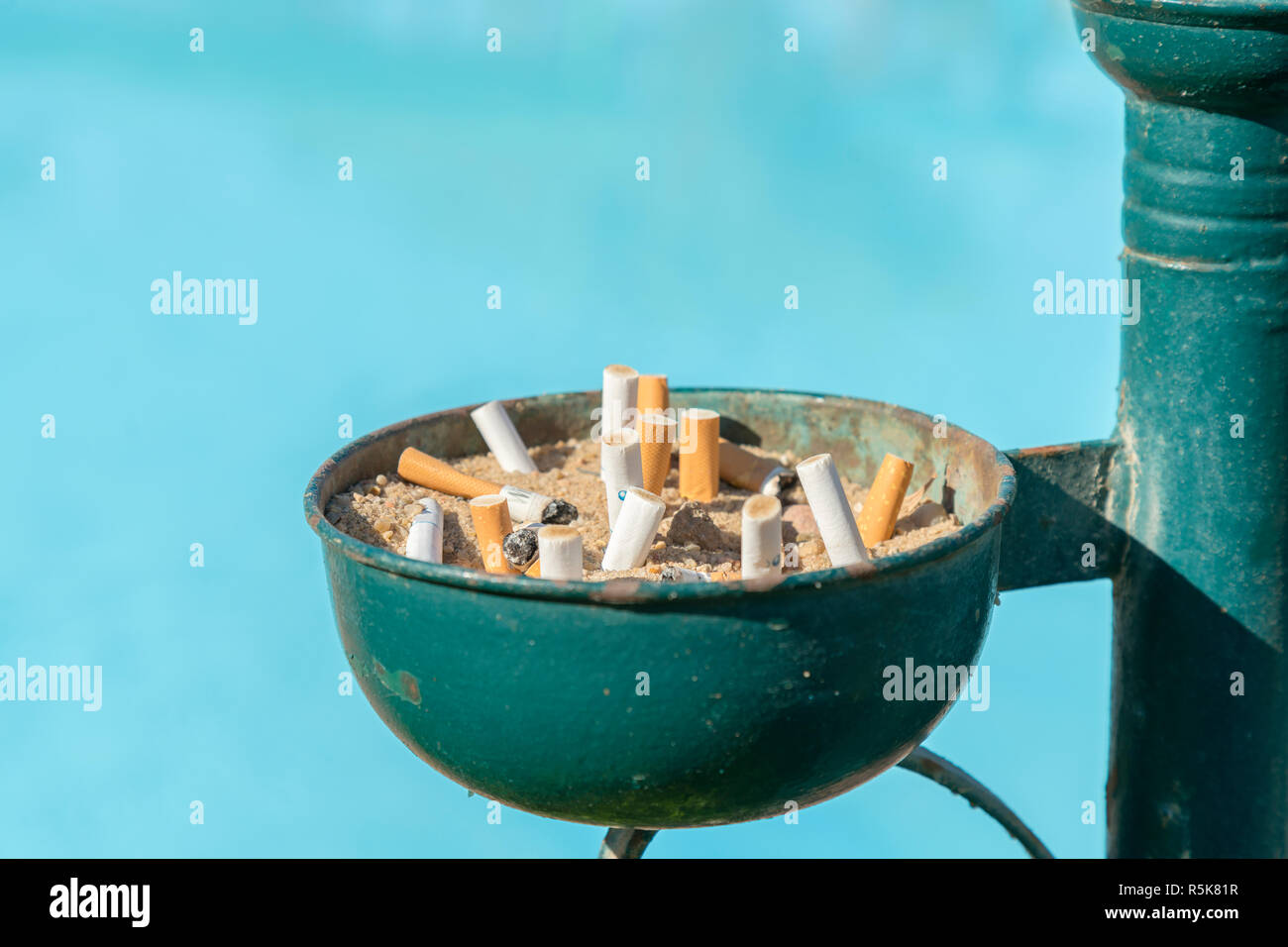 Cigarette butts in the urn. Cigarette disposal urn full of cigarettes