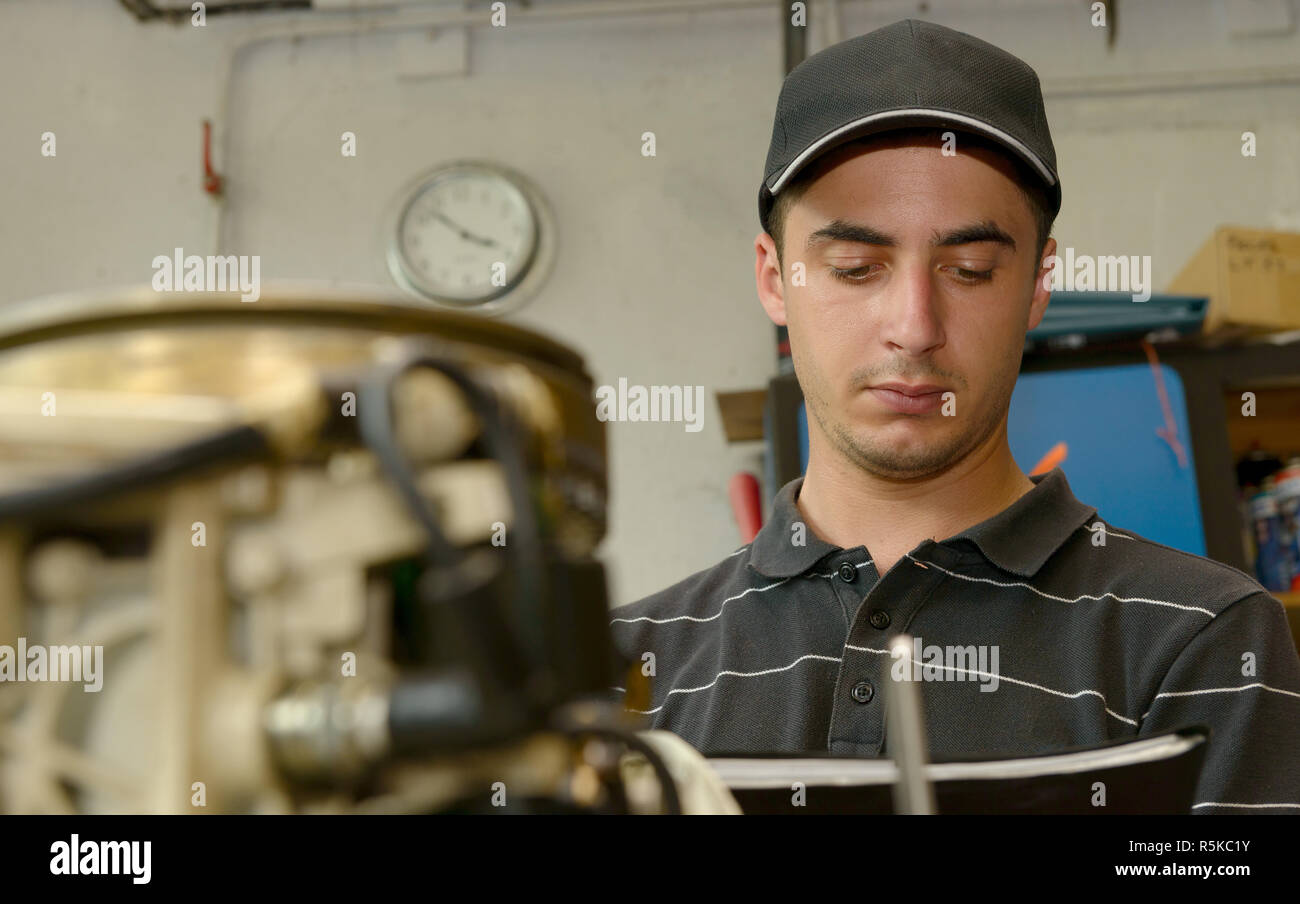 young mechanic checking the small boat engine Stock Photo Alamy