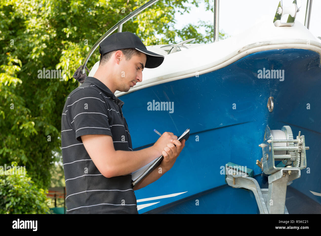 young mechanic checking the motor boat Stock Photo Alamy