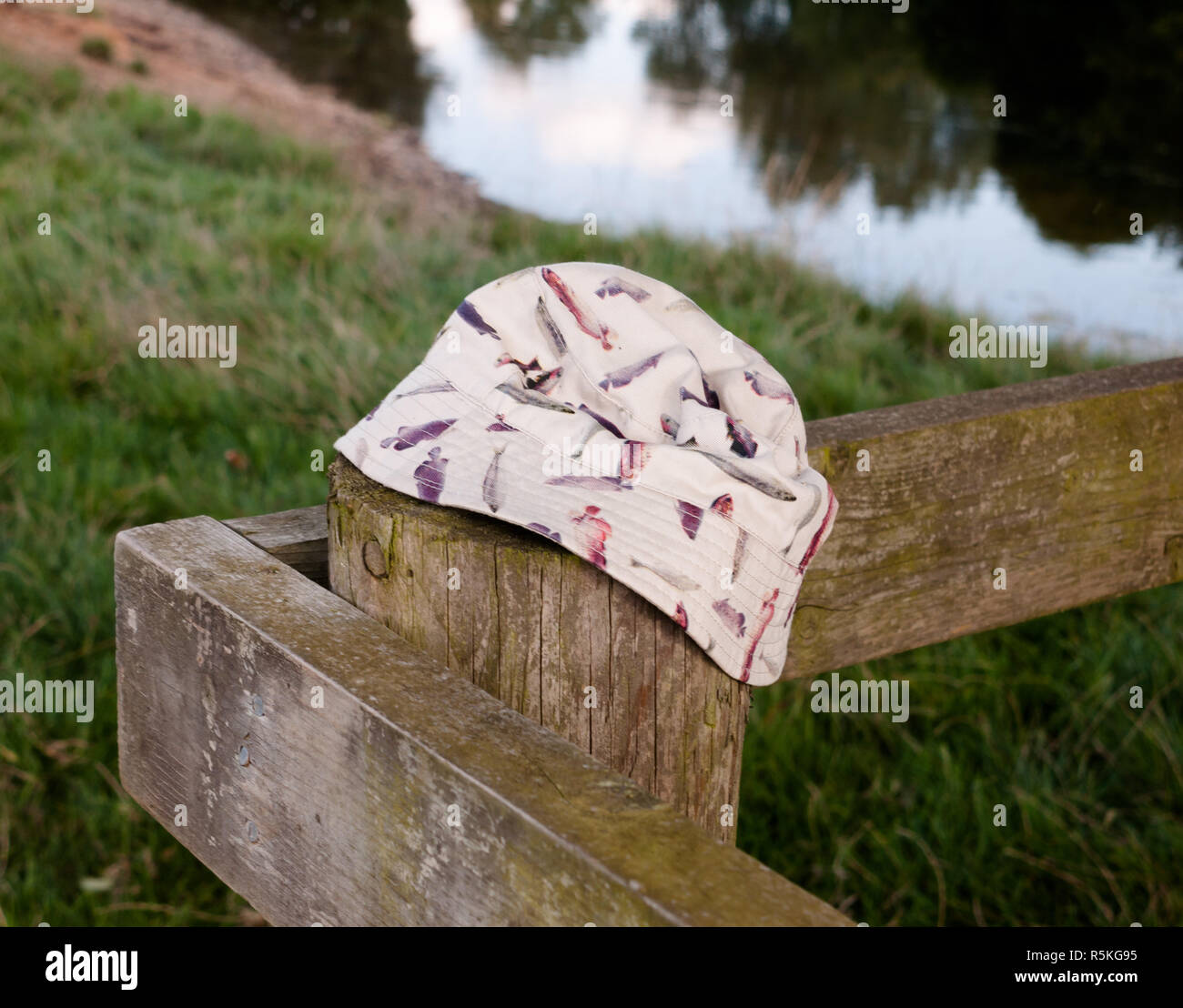 a bucket hat placed on a wooden post Stock Photo