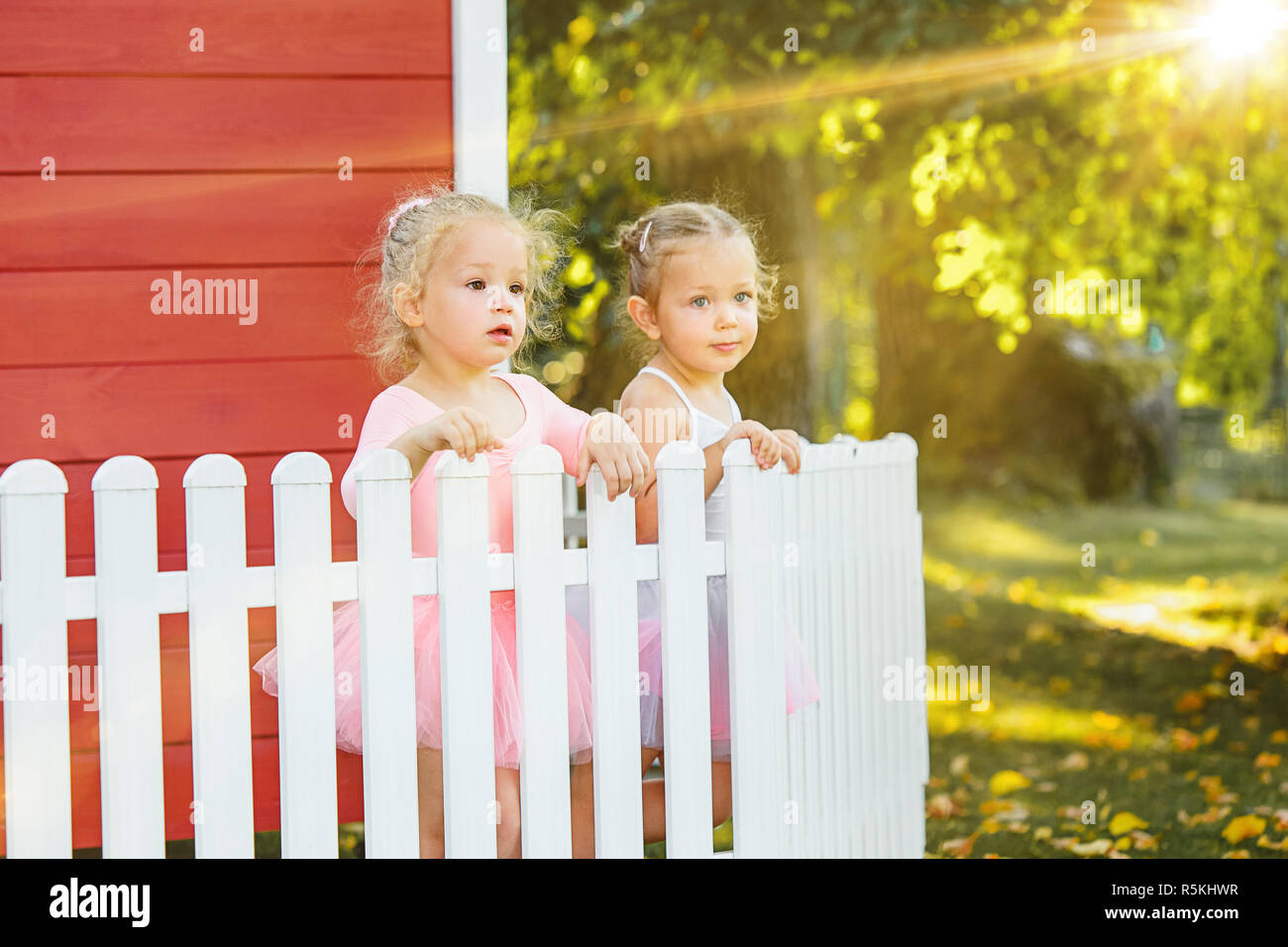 The two little girls at playground against park or green forest Stock