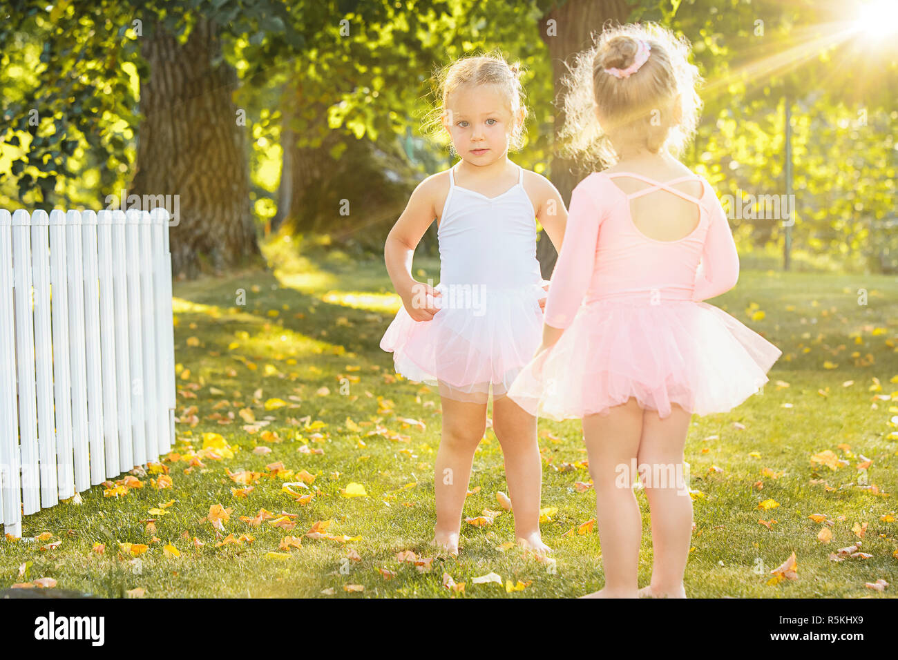 The two little girls at playground against park or green forest Stock