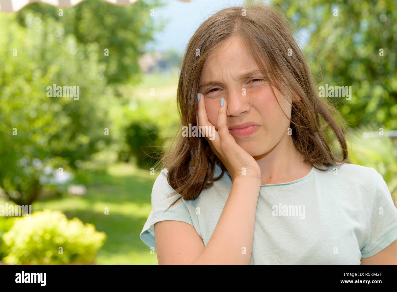 Young cute child girl have a toothache Stock Photo Alamy