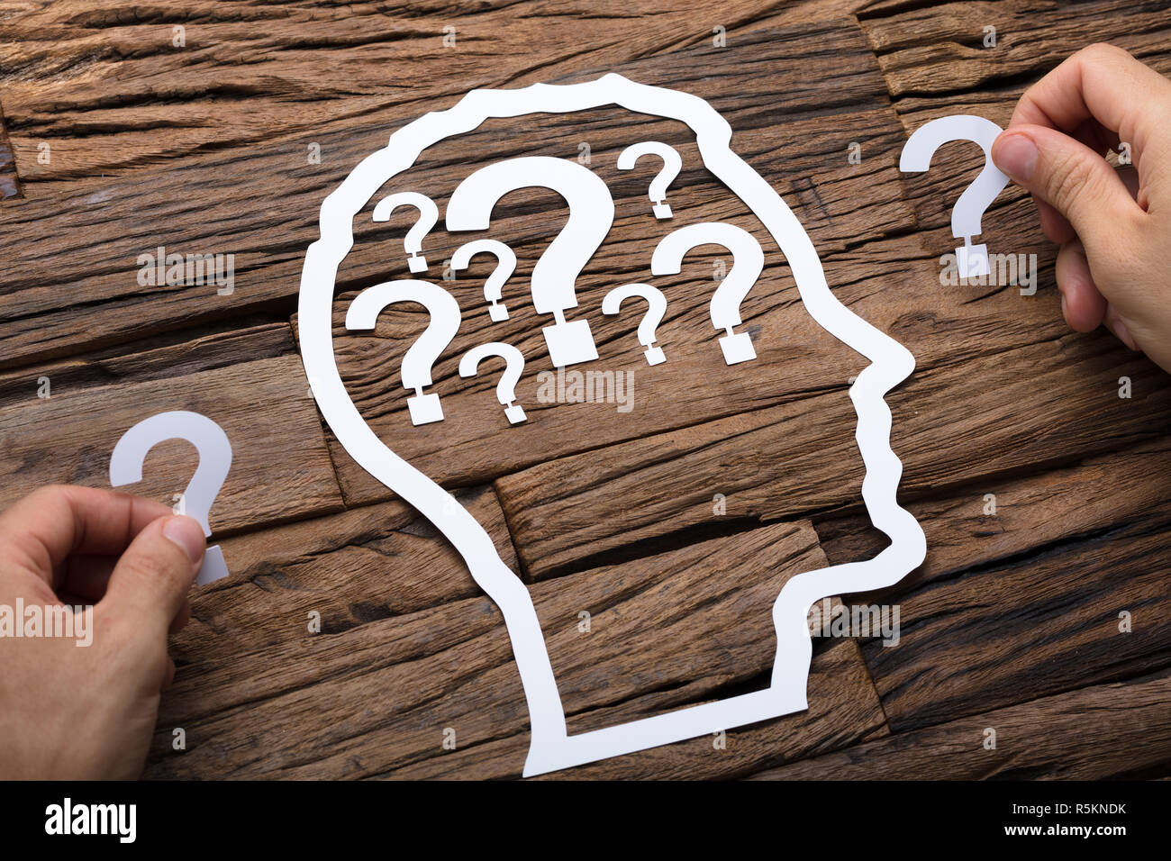 Businessman Holding Question Marks By Paper Head Outline Stock Photo