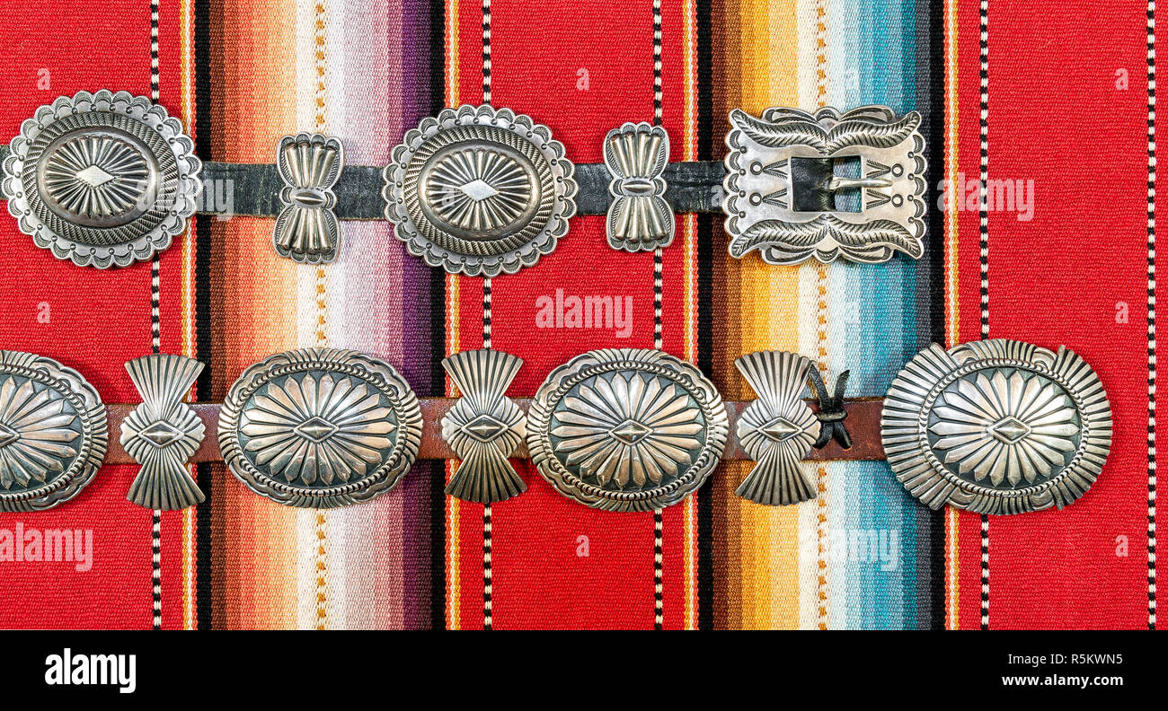 Sterling Silver Native American Concho Belt on Brightly Colored Southwestern Pattern Fabric. Stock Photo