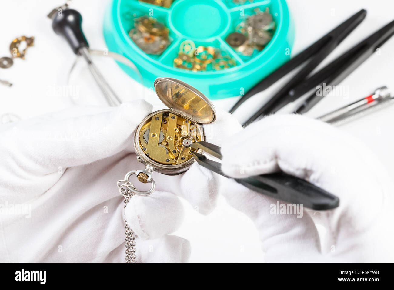 adjusting of brass pocket watch by tweezers Stock Photo Alamy