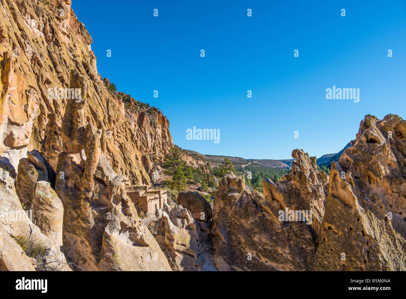 Colorful jagged rock formations, high cliffs, and ancient adobe ruins in Bandelier National Monument near Santa Fe, New Mexico Stock Photo