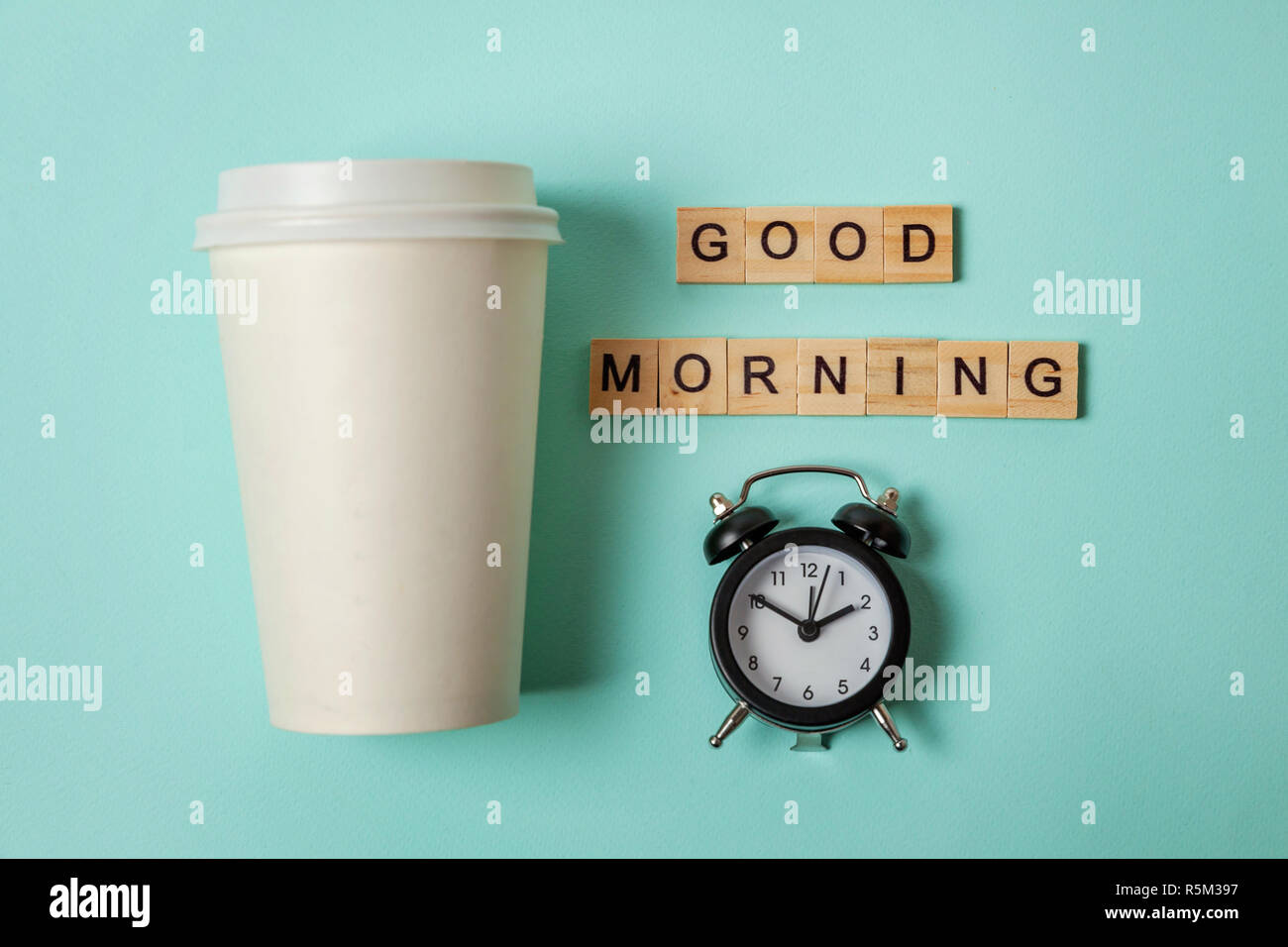 Simply flat lay design paper coffee cup and alarm clock on blue pastel ...