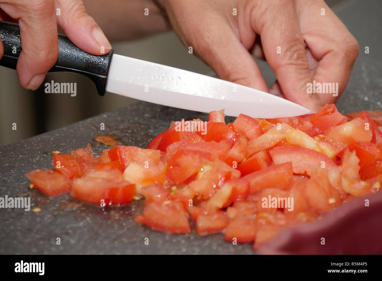 woman cutting tomato with the knife, on a plate Stock Photo Alamy