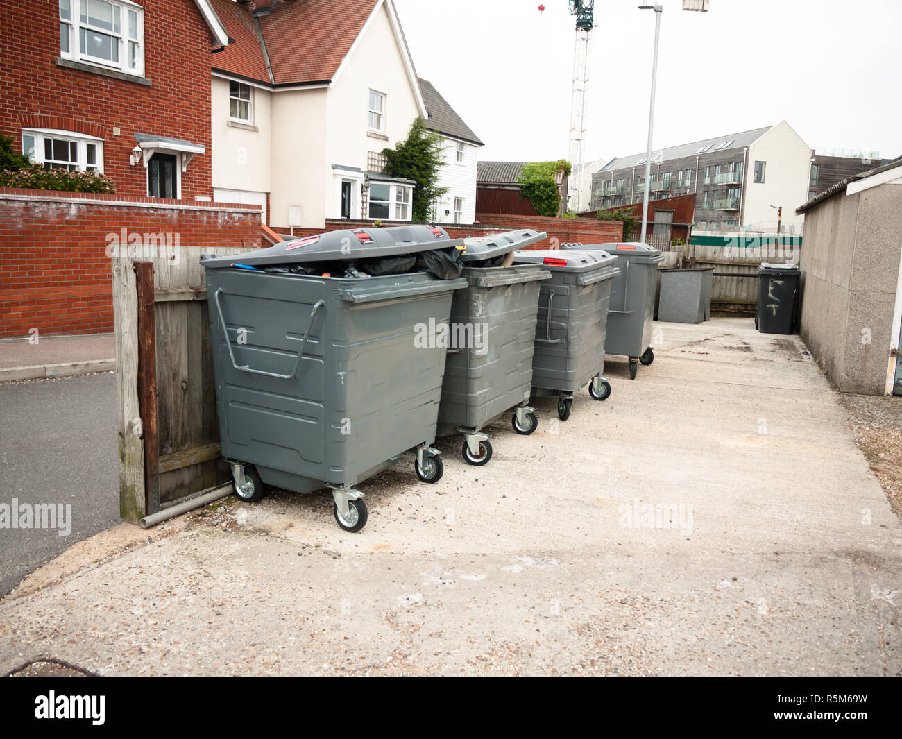 a row of black waste bins outside full Stock Photo Alamy