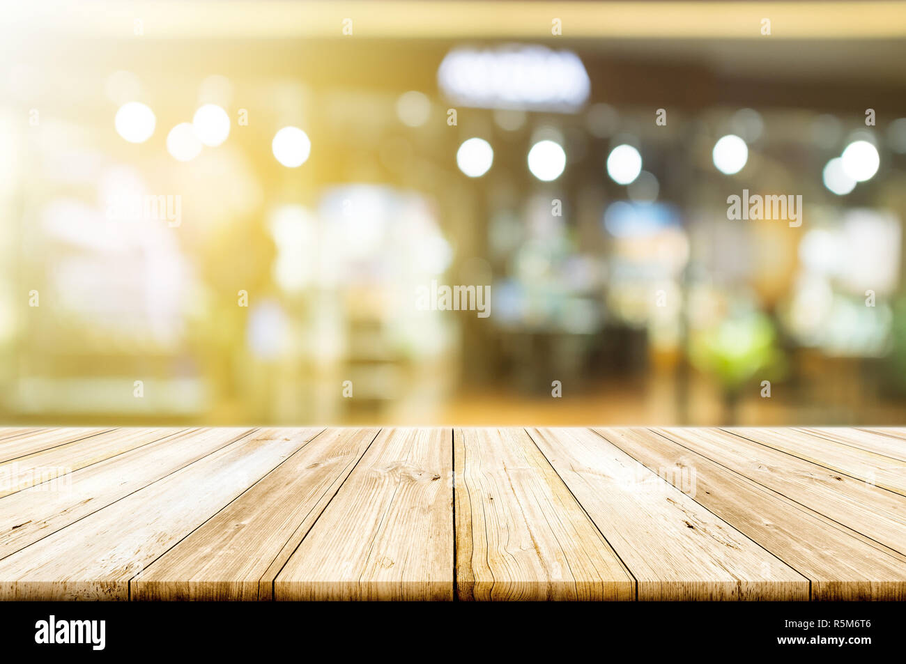 Empty wooden table top with blurred restaurant or cafe light background ...