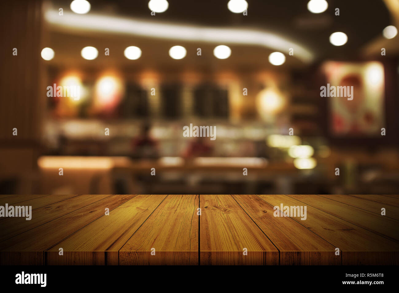 Empty wooden table top with blurred restaurant or cafe light background ...