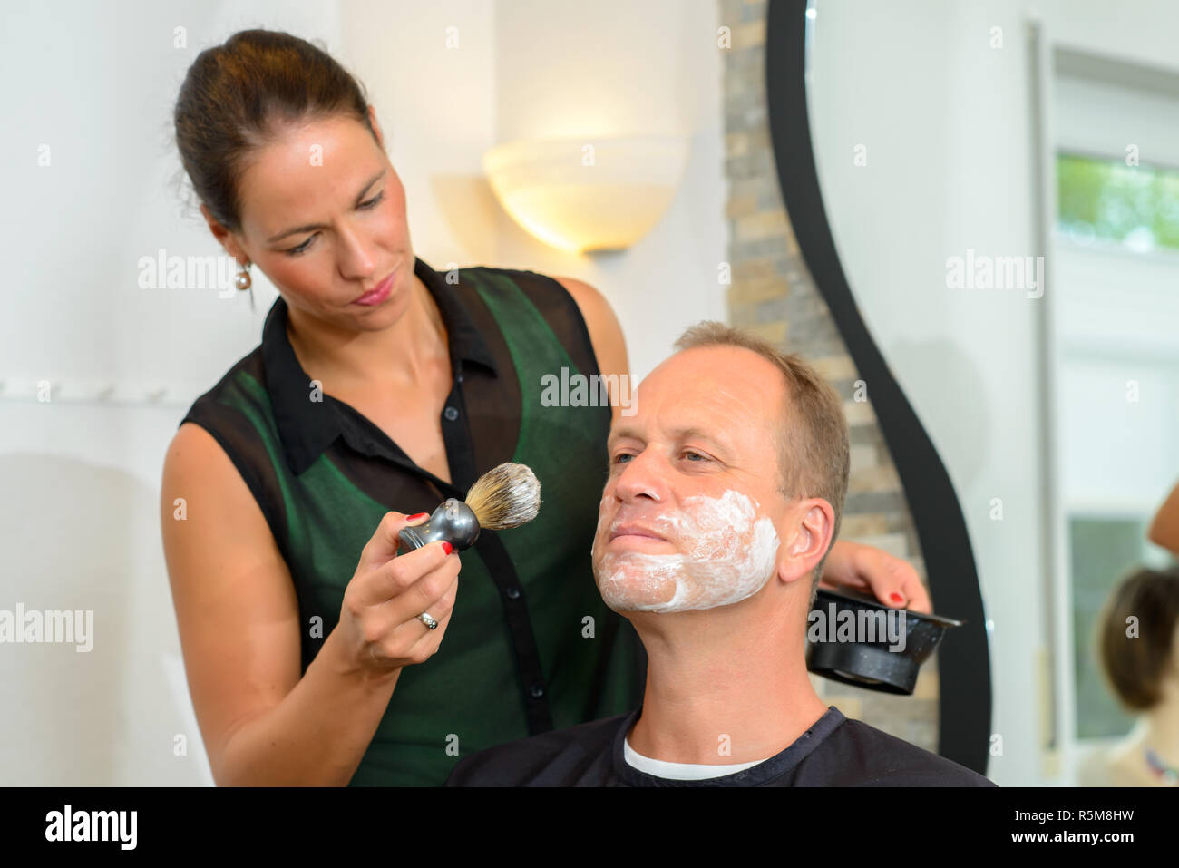 female hairdresser shaving beard of man Stock Photo Alamy