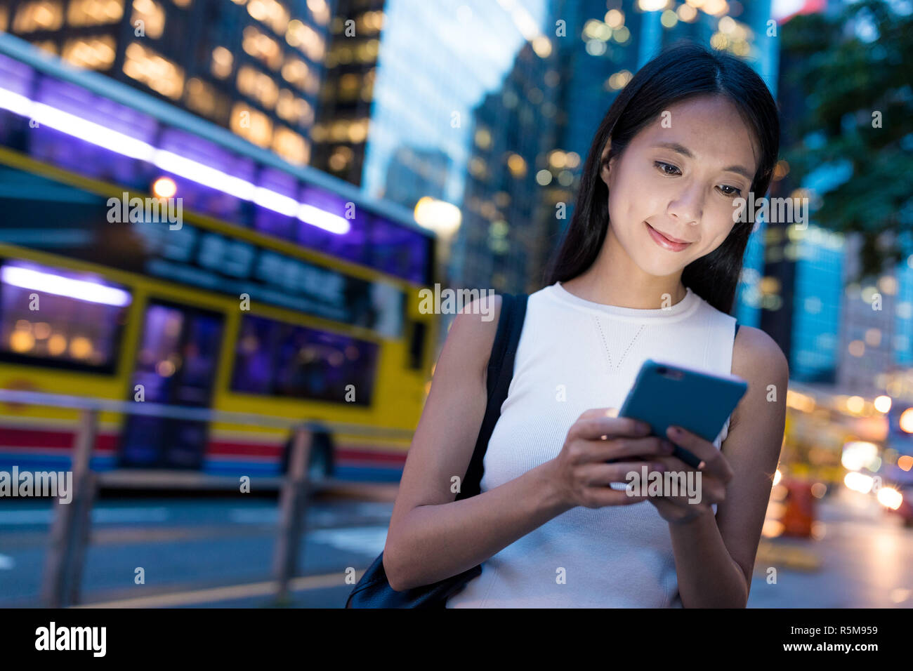 Woman using cellphone in Hong Kong city at night Stock Photo - Alamy