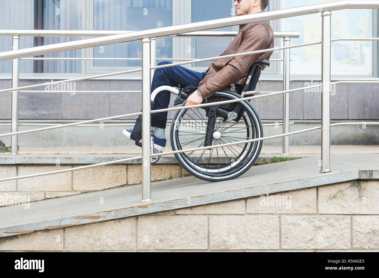 Man in a wheelchair use a wheelchair ramp Stock Photo - Alamy