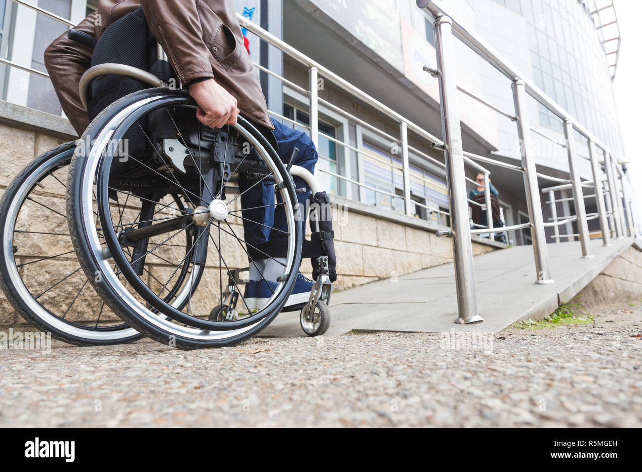 Man in a wheelchair use a wheelchair ramp Stock Photo - Alamy